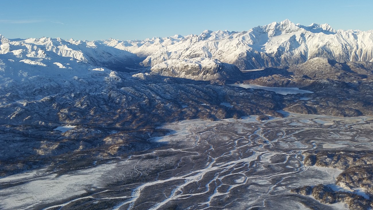 connected conservation snow capped mountains with a braided river valley