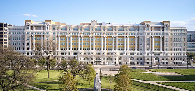 A large predominately white building with ornate columns.