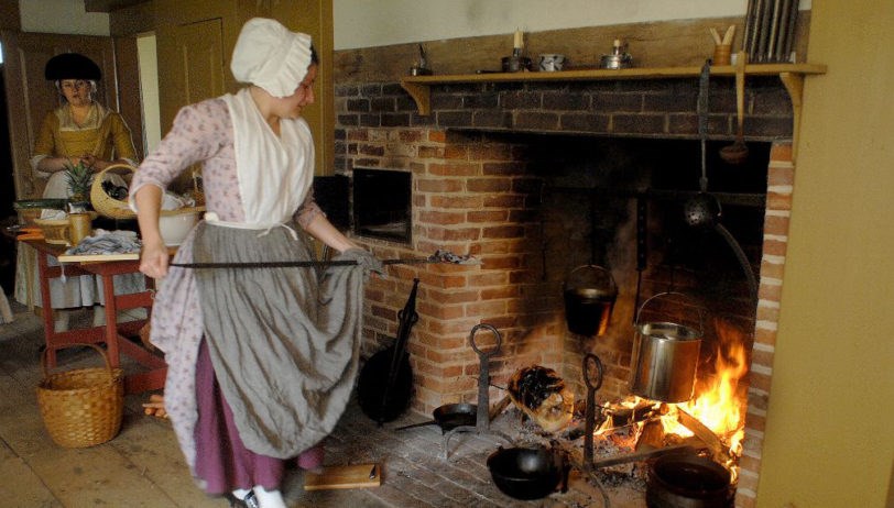cooking over a fire Photo of a woman cooking over an open fire in colonial dress