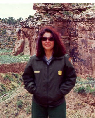 Judith Cordova Women in NPS uniform standing in front of a rock formation.