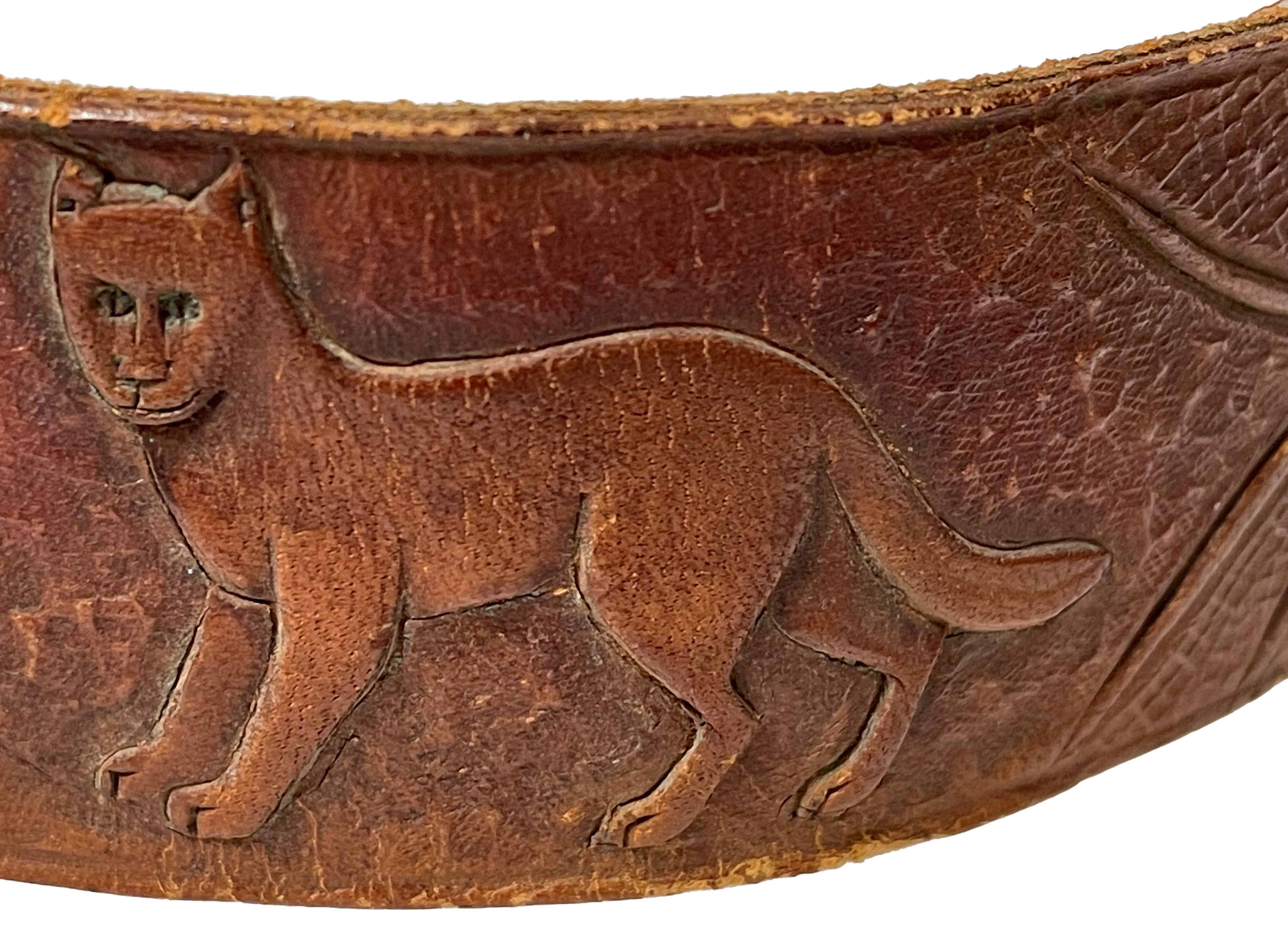 Mountain lion detail on Albright's hatband. Close up of a cougar etched on a band of leather.