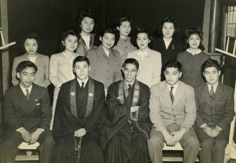 A black and white photograph of a group of young Japanese Americans, with five men in the front and seven women in the back.
