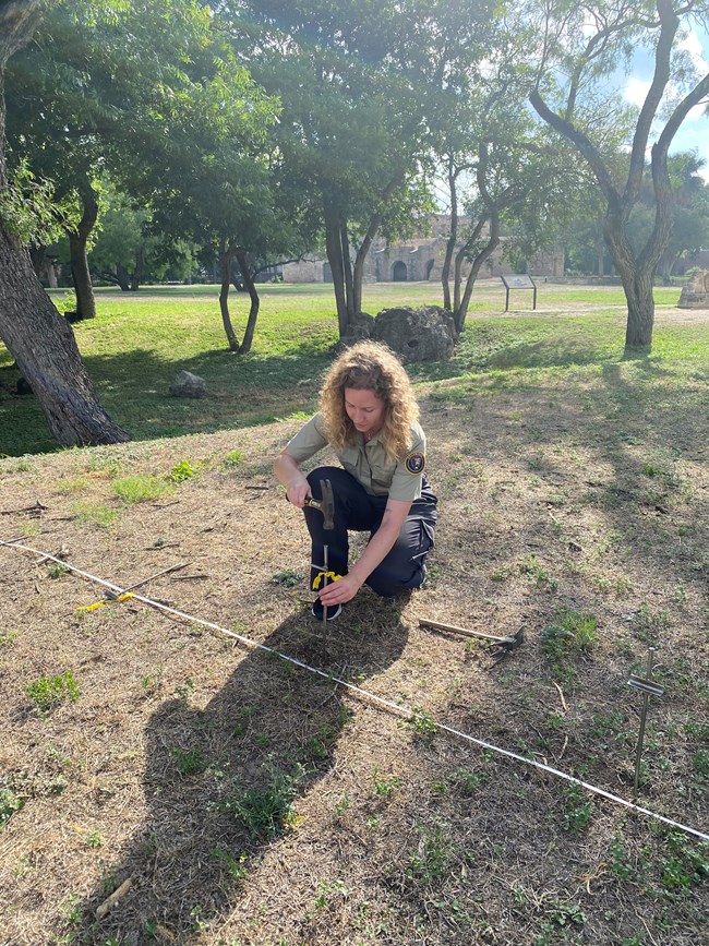 Woman hammering a nail in the ground