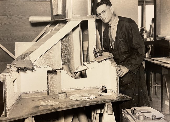 Elmer Duffield standing next to a diorama he is working on.