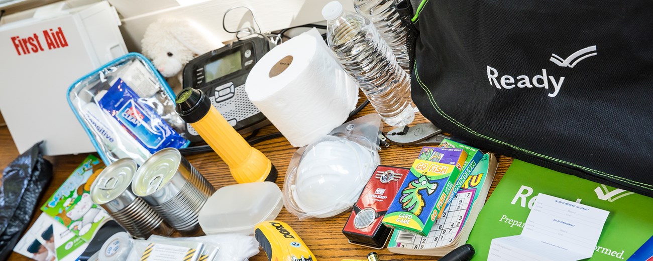 Prepare an emergency go kit emergency supplies from a go kit set out on a table