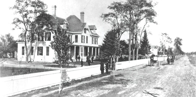 White farm house next to a dirt road