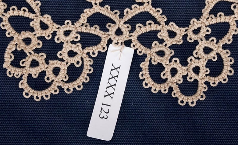 Looped label around lace element.