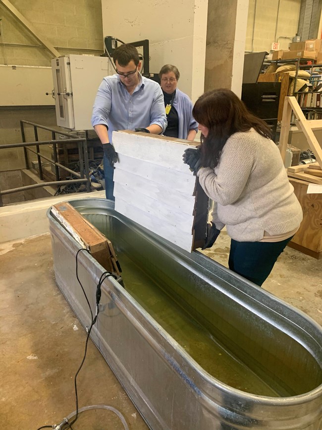 People placing a building materials sample in a vat of water