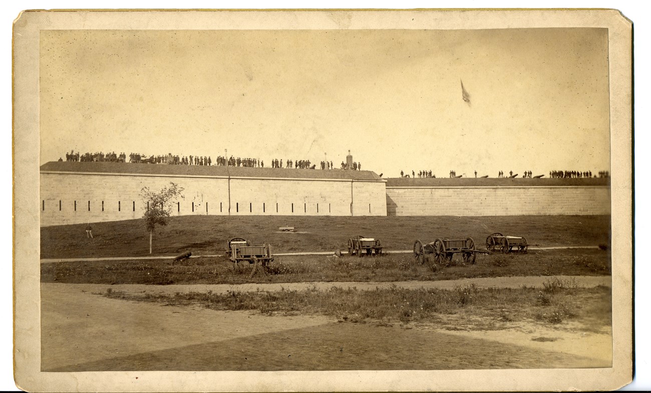 Fort Warren exterior. Soldiers are along the ramparts.