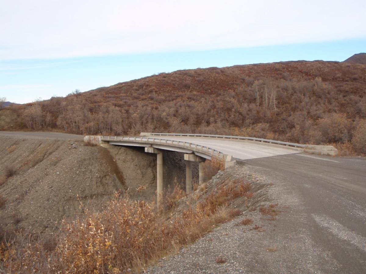 g-2 a dirt road with a bridge spanning a narrow defile