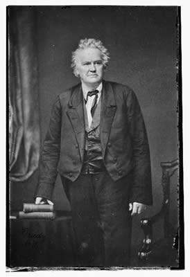 white haired man who is wearing a rumpled suit