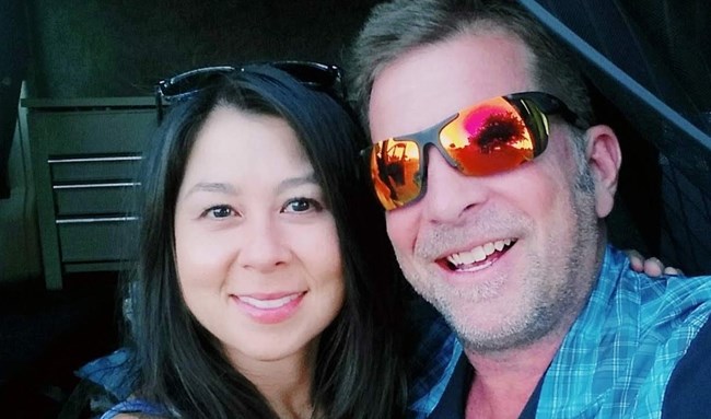Two smiling people look at the camera.