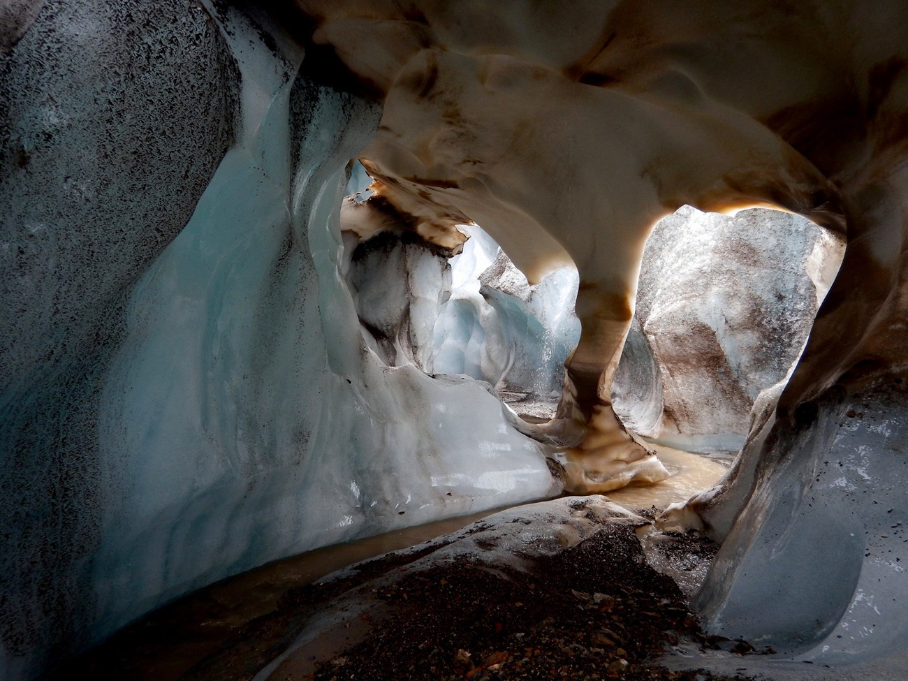 glba Ice pillar in an ice cave in Brady ice field ice cave interior with gravel floor and a small stream
