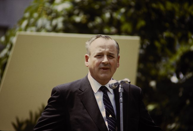 George Hartzog in a suit speaks at a podium