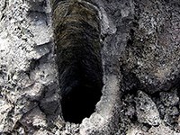 photo of a vertical round hole in lava rock