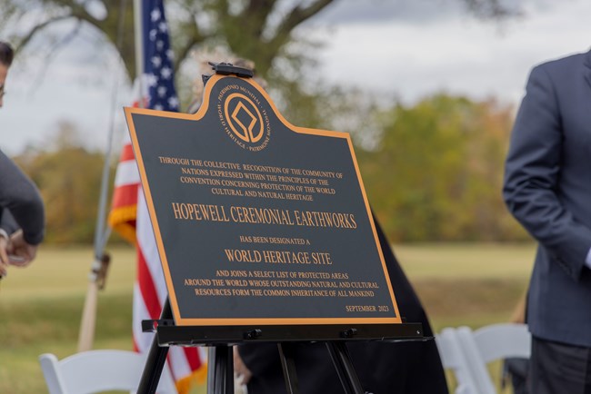 World Heritage plaque at Hopewell Culture National Historical Park. Plaque on easel with American flag behind it.