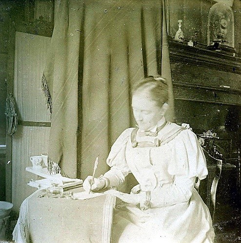 Helen Black and white photo of Helen Ridgely writing at a desk.