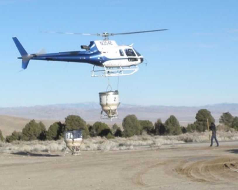 helicopter with hopper Helicopter returning with empty hopper after seeding.