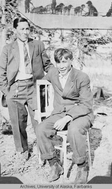 historic photo of two alaska native men in suits sitting oudoors