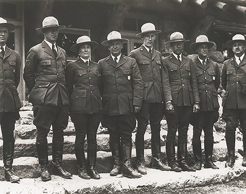 Eight rangers standing shoulder to shoulder wearing the standard uniform in June 1933. Ranger-naturalist Herma Albertson Baggley is third from the left.