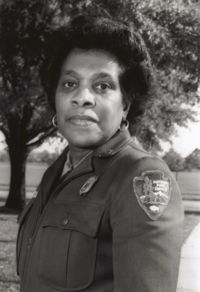 Georgia Ellard in uniform Georgia Ellard posing in her NPS uniform with a tree behind her.