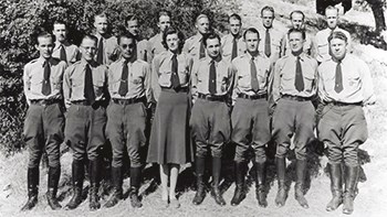 Two rows of uniformed rangers stand with their hands clasped behind their back facing forward.