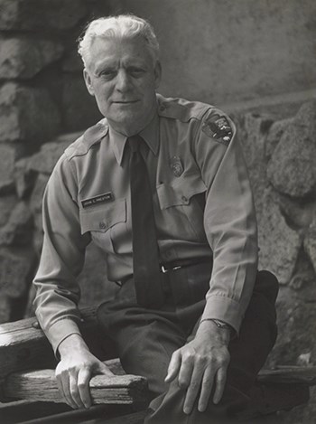 hfca_1607_preston_john_u NPS Uniform Committee Chairman John C. Preston wears a long sleeved shirt, tie and name tag. The NPS arrowhead patch can be seen on his left arm.
