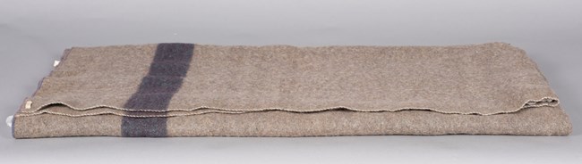 Mather's wool blanket Folded gray blanket with a blue stripe