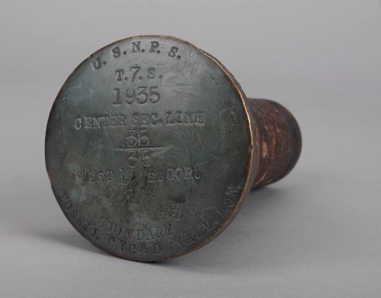 Boundary Marker Cap from Fossil Cycad Bronze boundary marker cap including NPS, Fossil Cycad National Monument, and 1935 date.