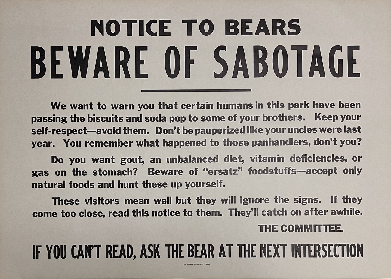 Poster with black letters warning bears that people are trying to sabotage them by feeding them