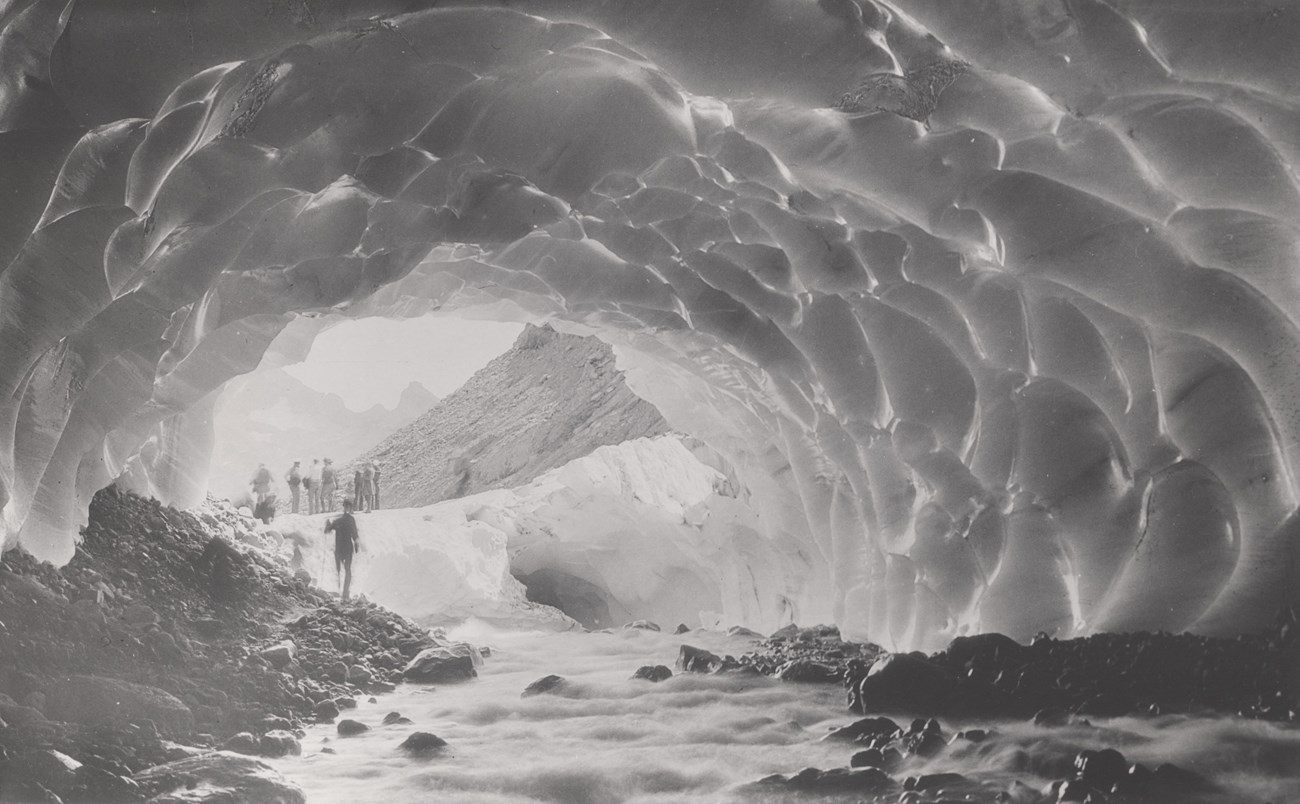 People standing in and near a faceted ice cave