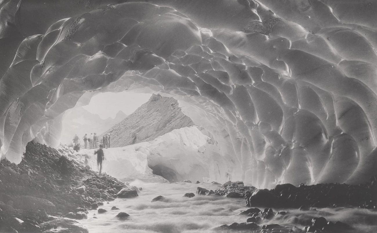 Ice cave. People standing in and near a faceted ice cave