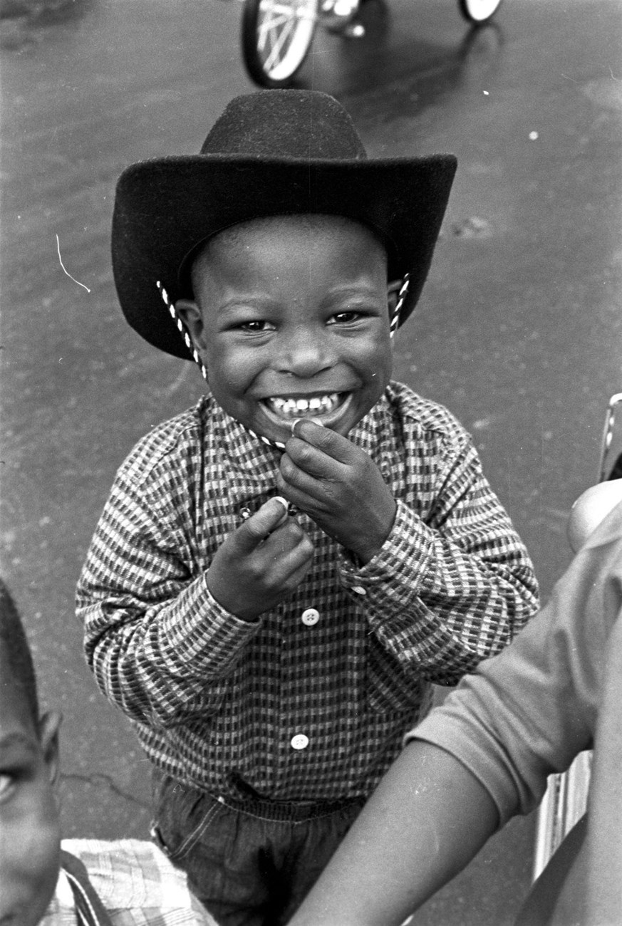 Black and white photo of a little boy wearing a cowboy hat