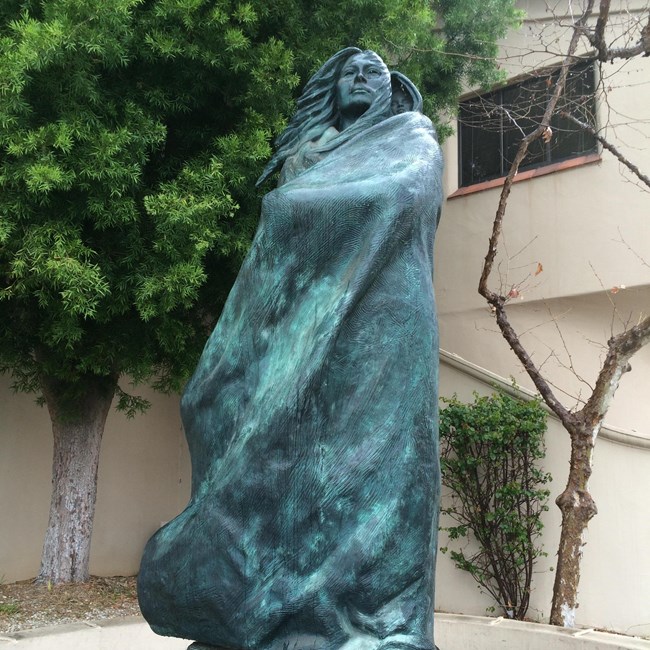 Sacagawea_Statue A statue of a native woman holding a baby on her back