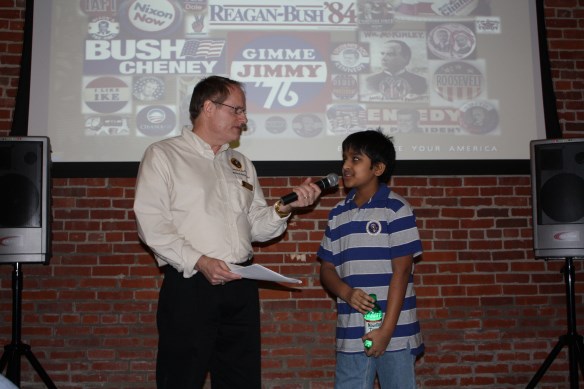 man with a mircrophone is talking to a younf boy