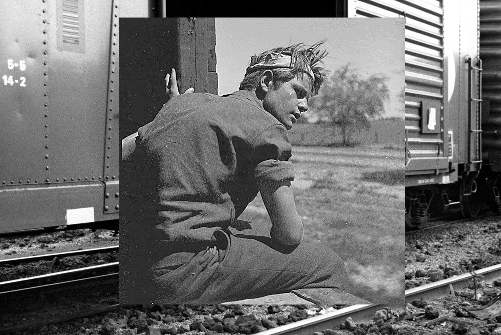 Black and white photo of man on a train