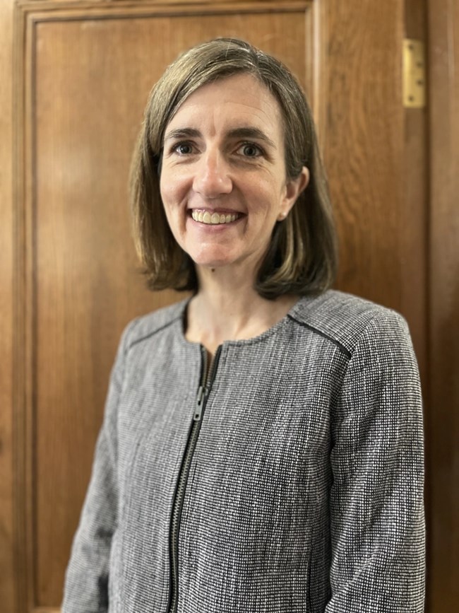 a women standing in front of a wood door smiling