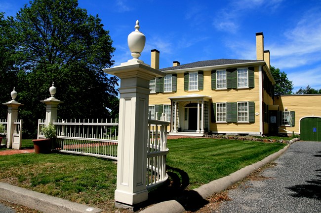 Large yellow house with gate.