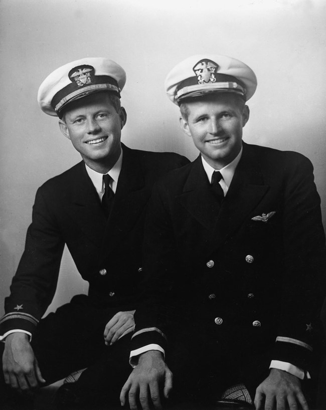 A black and white photo of Joseph Jr. (right) and John Kennedy (left) in their service uniforms.