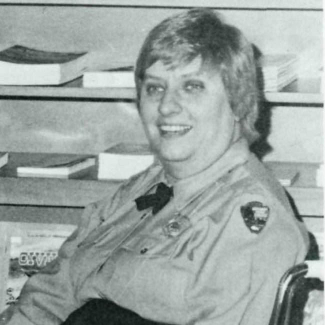 Park Aide Joanne Hodges Joann Hodges siting in her wheelchair. She wears a long-sleeved NPS uniform shirt and cross tie.