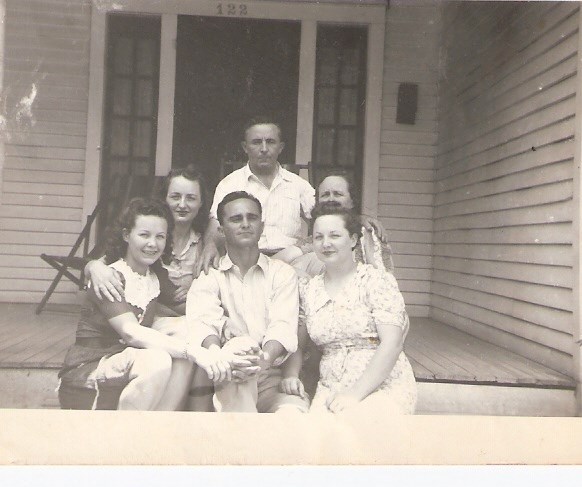 Johnson Family in 1941 Family of six seated for casual portrait on house porch.