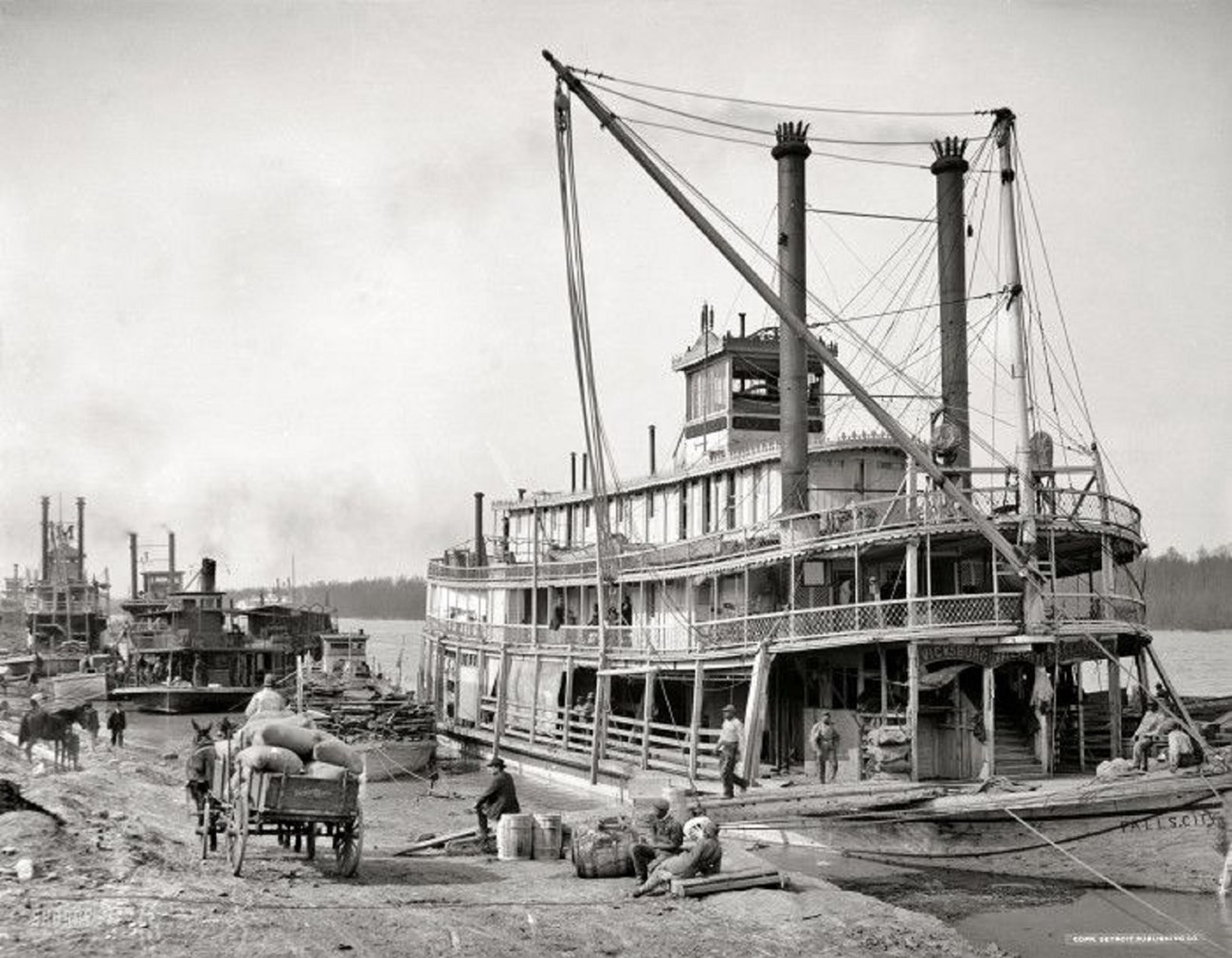Black and White photo of steamboat loading on wharf 1900