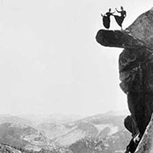 two women in long skirts dance on a rock  high above the ground