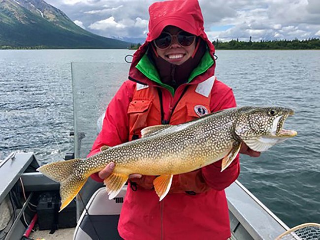 A woman holds a lake trout