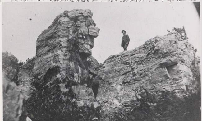 Leaping Rock black and white photo of a man standing on a cliff