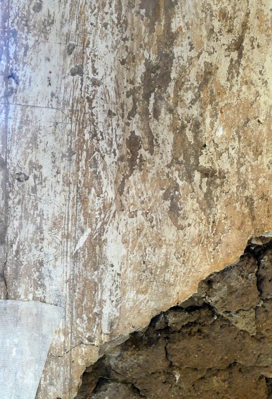 lt= plaster wall with tool and incision markings