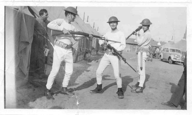 three young soldiers show off heir new long underwear while holding guns