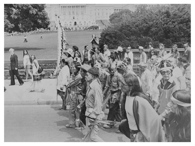 Group of people marches past Capitol building