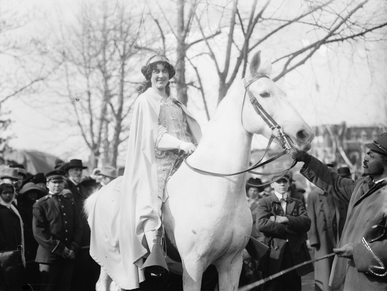 Inez Milholland leading the Woman Suffrage Procession. White woman wearing a cape riding a white horse