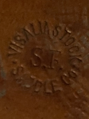 Close up of leather stamp reading Visalia Stock Saddle Co with SF in the middle